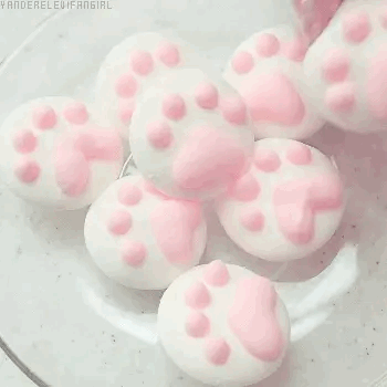 gif of someone placing a softcore pink and white cat paw marshmellow on top of a bunch of others slash duplicates